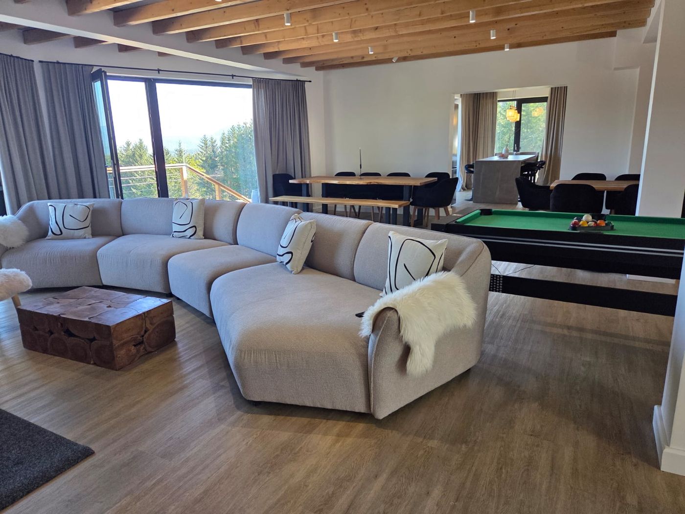 Living spațios cu canapea mare, masă de biliard și zonă de dining