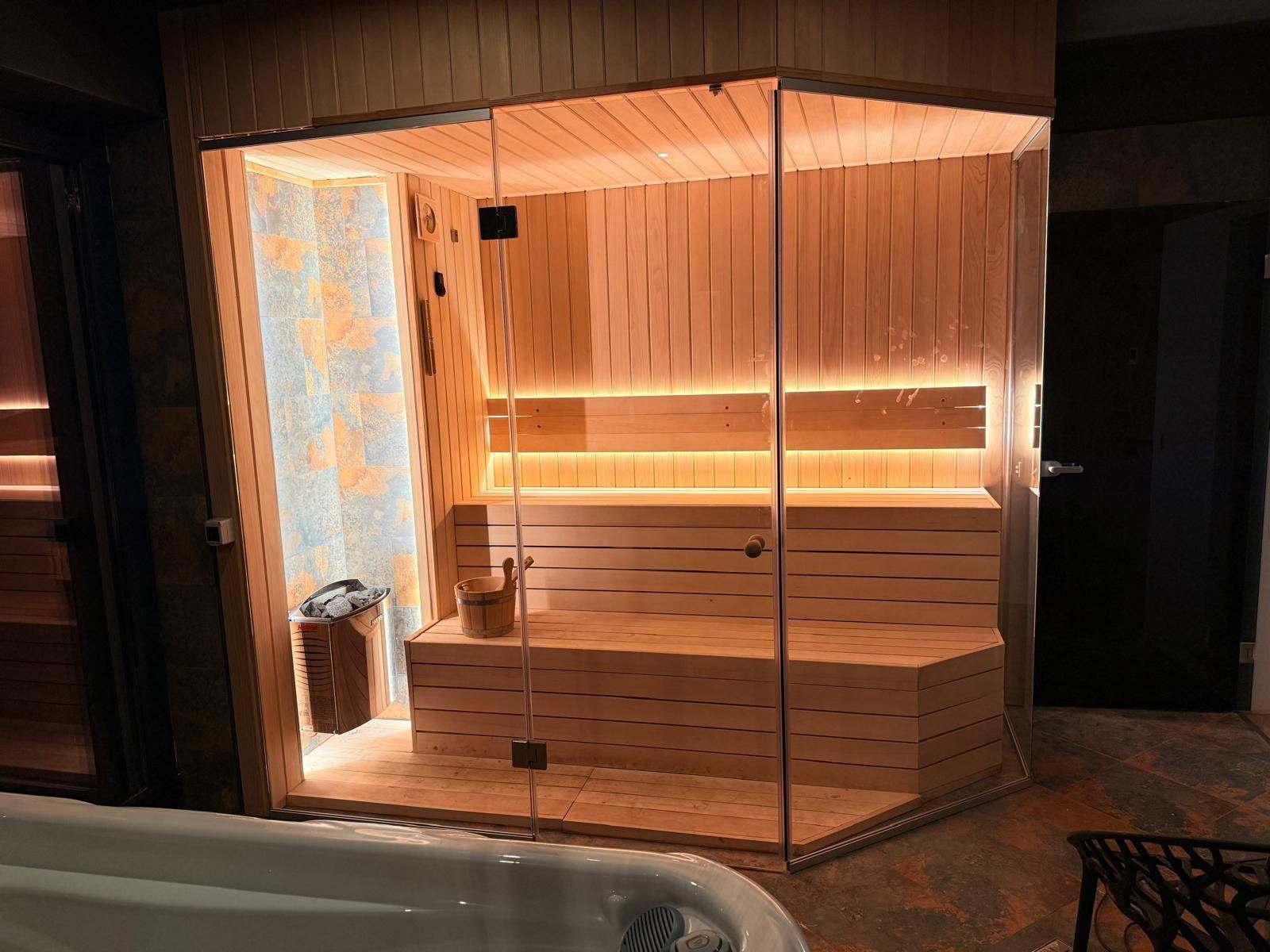 Sauna din lemn cu lumină caldă și jacuzzi-ul din zona de wellness